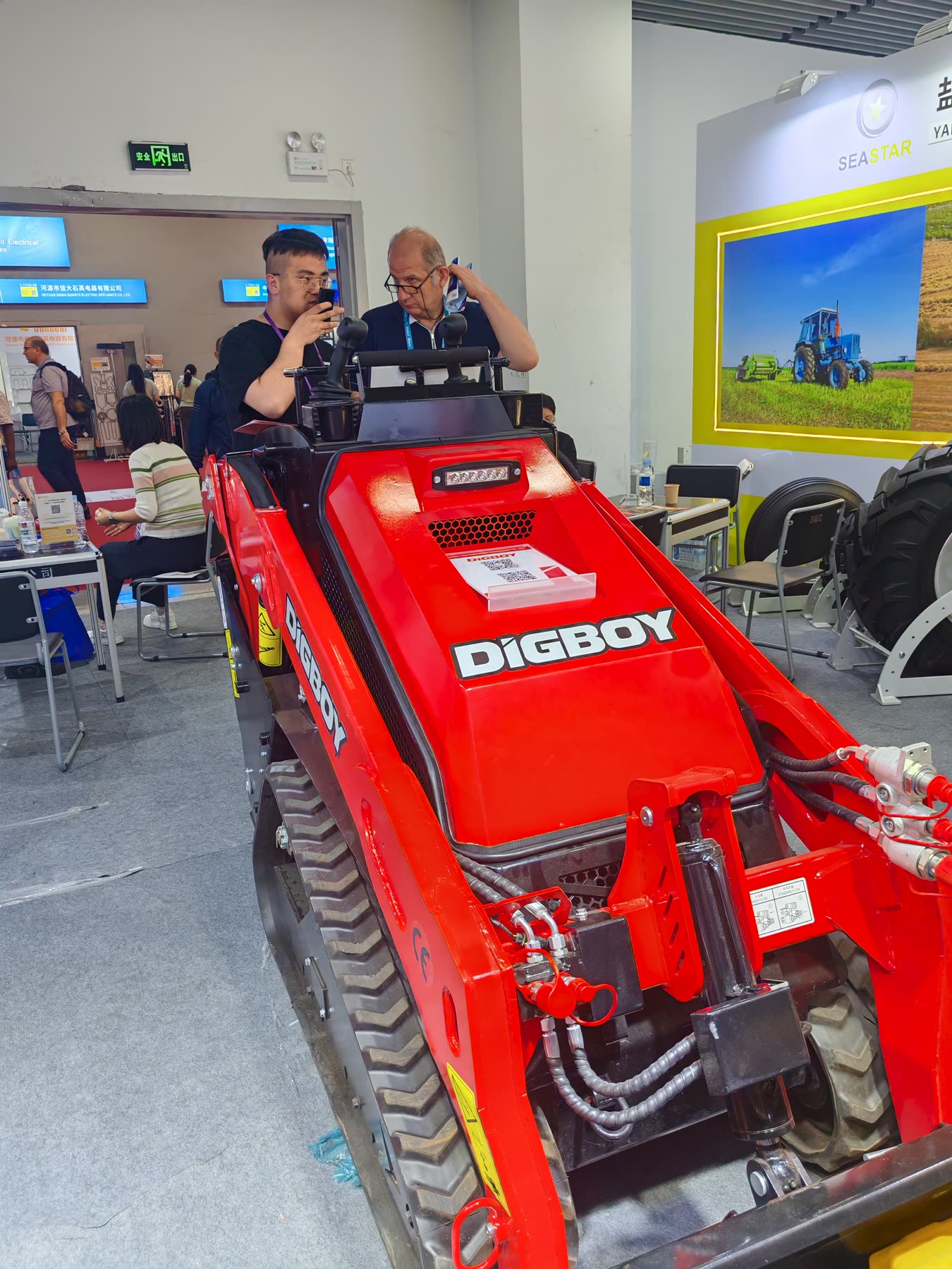 Buyer inspecting the DIG-BOY V1000 loader at exhibition booth